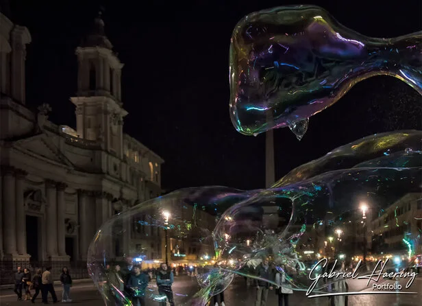 Soap bubbles floating at night near Piazza Navona in Rome